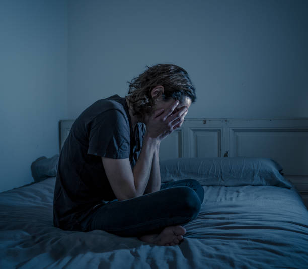 istock Devastated millennial man crying sad feeling hurt and hopeless suffering Depression. Depressed teenager victim of bullying or abuse sitting on bed alone in despair at night. In teenage Mental health. 1175452148