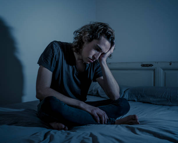 istock Devastated millennial man crying sad feeling hurt and hopeless suffering Depression. Depressed teenager victim of bullying or abuse sitting on bed alone in despair at night. In teenage Mental health. 1175452162