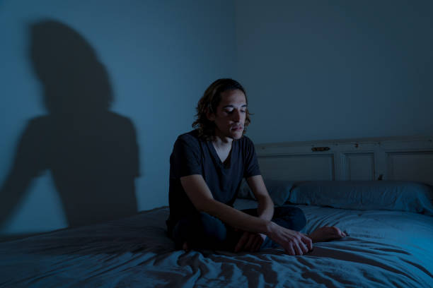 istock Devastated millennial man crying sad feeling hurt and hopeless suffering Depression. Depressed teenager victim of bullying or abuse sitting on bed alone in despair at night. In teenage Mental health. 1175452226