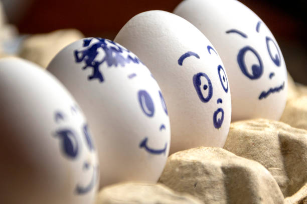 istock Lovely eggs in cardboard box. Eggs with emotions. White eggs in cardboard box with different faces painted on them. Boys and girl. 1175455167