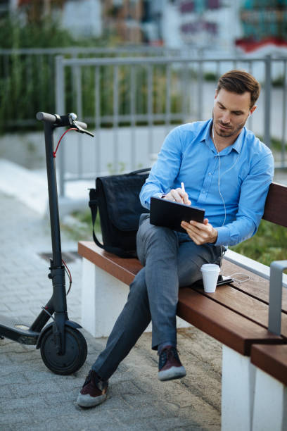 istock Businessman using digital tablet in the city park after scooter riding 1175456735
