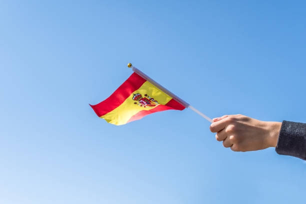 istock Boy holding Spanish Flag on the blue sky backgrouns. Concept. 1175458263