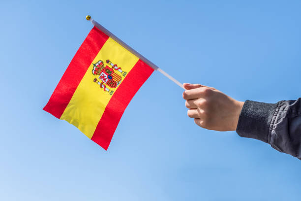 istock Boy holding Spanish Flag on the blue sky backgrouns. Concept. 1175458335