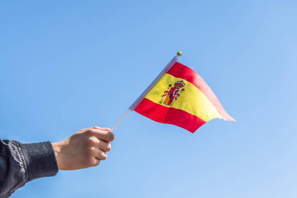 istock Boy holding Spanish Flag on the blue sky backgrouns. Concept. 1175458386