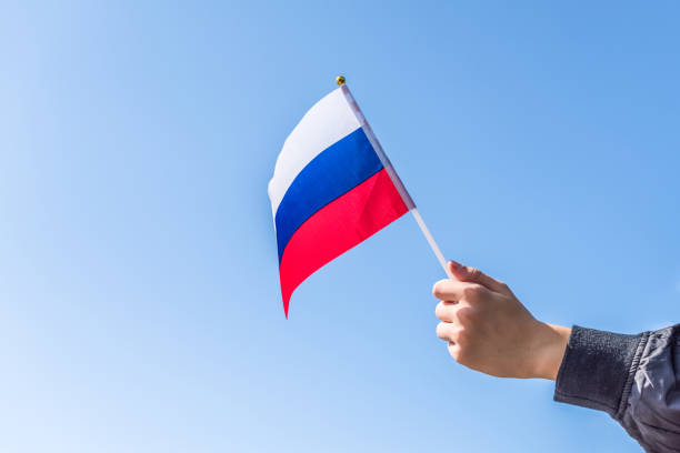 istock Boy holding Russian Flag on the blue sky backgrouns. Concept 1175458488