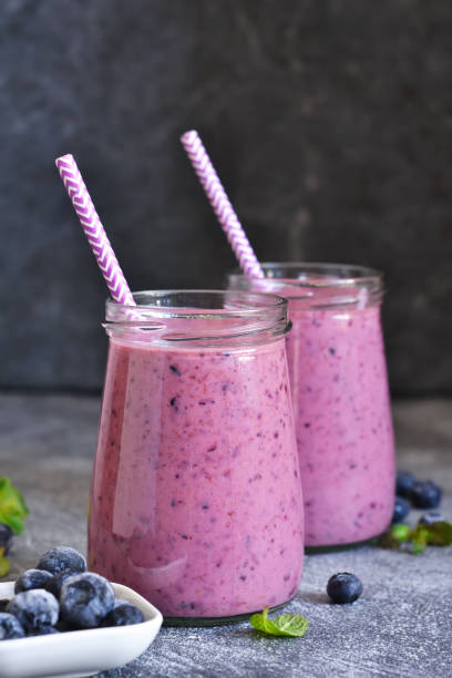 Purple smoothies with blueberries on the kitchen table. Detox menu. stock photo