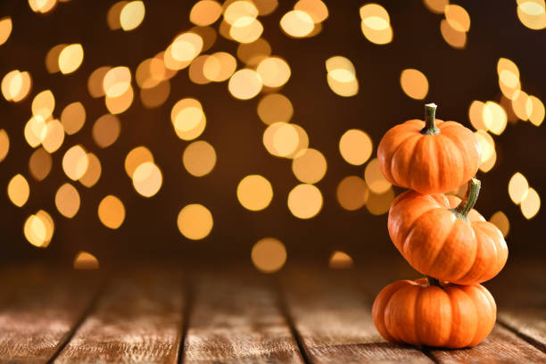 istock Thanksgiving still life with pumpkins and illuminated background on a rustic wooden table 1175459715