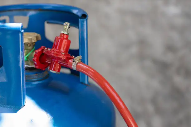 Rusty pressure regulator and operating valve of cooking gas tanks. LPG . Hose connect to the cylinder red gas supply.