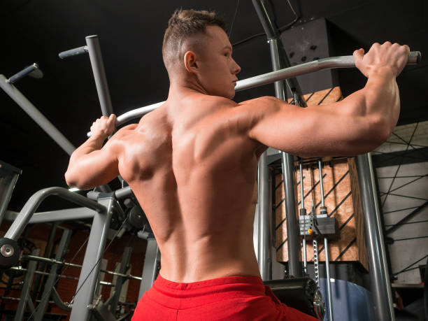 istock Athlete doing workouts on a back with power exercise machine in a gym club. 1175462942