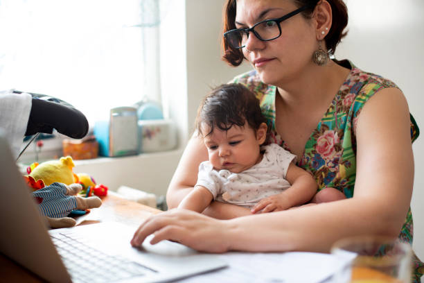 Working mom with baby in a lap stock photo