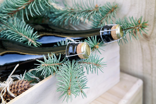 sparkling wine bottles and Christmas decor in a wooden box for delivery, New Year holidays