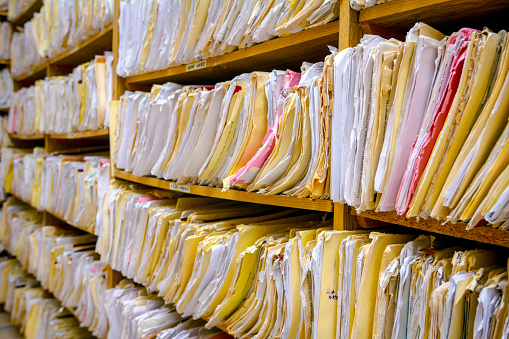 Shelves are full with folders and files of medical record, patient information.
