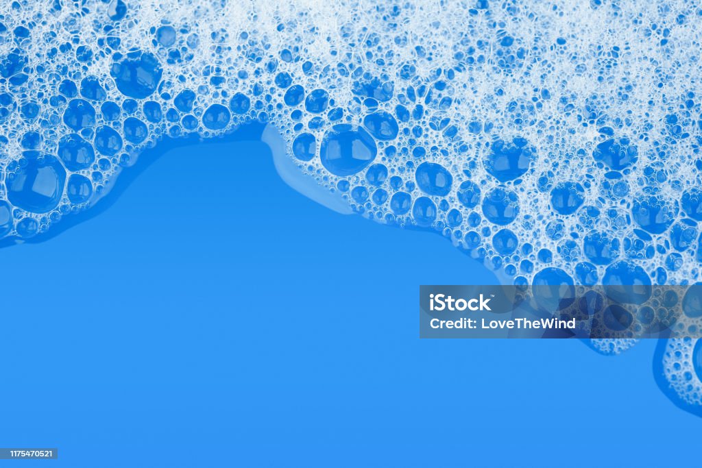 Bubble foam soap shampoo on blue water surface texture background top view Soap Sud Stock Photo