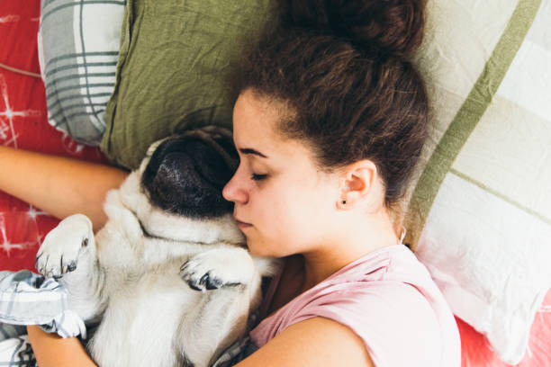 istock Young woman sleeping with her dog 1175470666