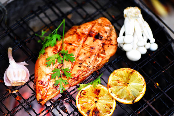 chicken breast grilled with garlic chilli herbs and spices and lemon on grill top view - Roast BBQ chicken breast steak