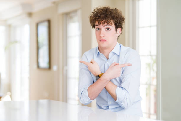 istock Young business man with curly read head Pointing to both sides with fingers, different direction disagree 1175473113