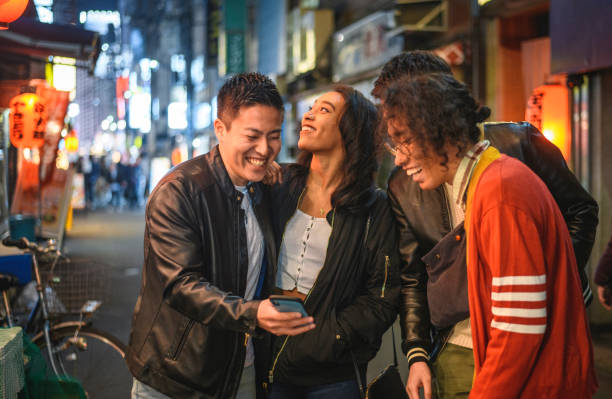 Laughing Young Friends Checking Smart Phone in Tokyo