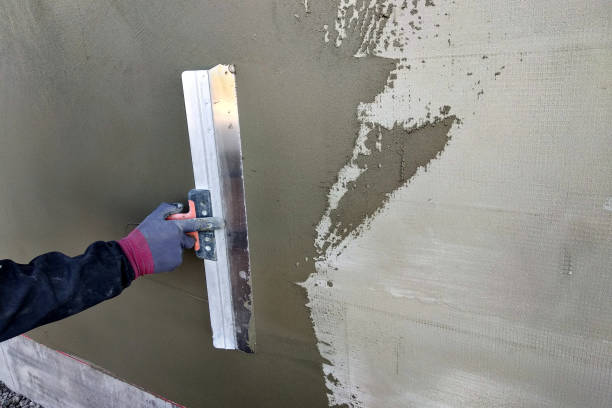 istock Worker covering insulated wall with solution of glue over plastered styrofoam insulation. 1175475789