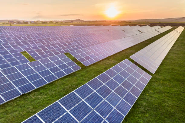 istock Blue solar photo voltaic panels system producing renewable clean energy on rural landscape and setting sun background. 1175476079