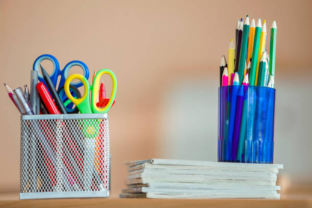 istock Stack of notebooks, colorful drawing pencils and stationery arrangement on copy space background. 1175476150