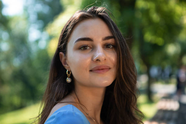 istock Smiling woman in a blue dress sits in a park. Enjoying life 1175478564
