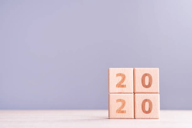 istock Abstract 2020 design concept - geometric wood blocks cubes on wooden table and low saturation gray blue background. 1175478574