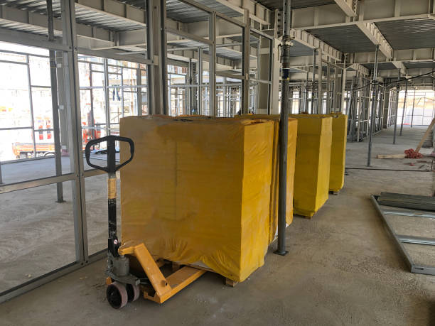 istock Piled cinder blocks wrapped in yellow packaging on the floor of the prefabricated multi-storey building 1175480037