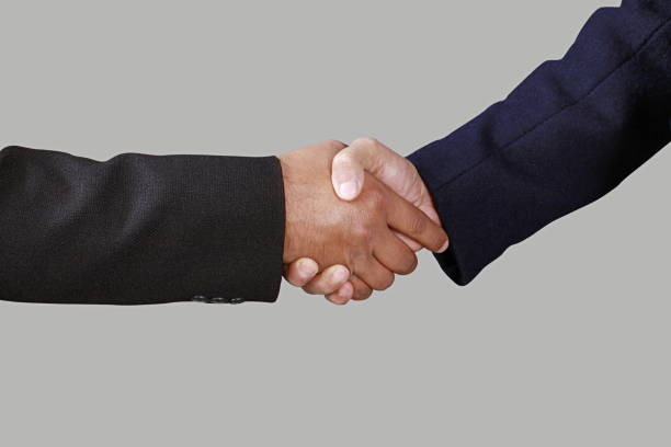 istock Official handshake. Two men in suits shaking hands, making a deal. 1175481474