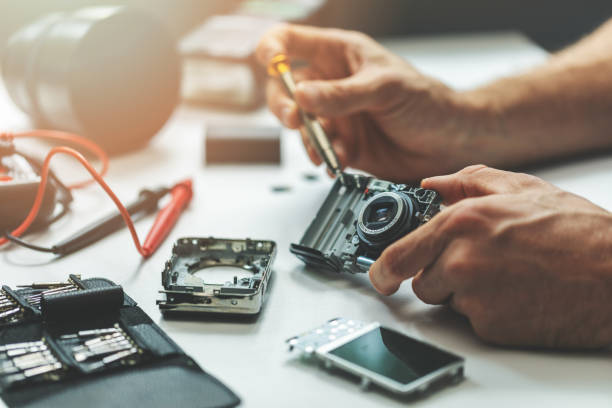 istock electronic repair service - technician repairing digital camera in office 1175483319