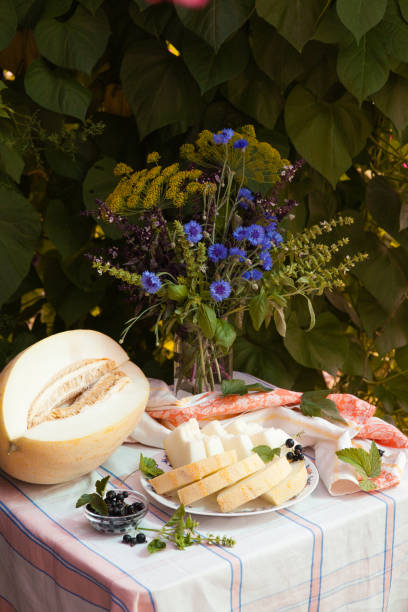 istock Still life with melon and bouquet of cornflowers on white tablecloth 1175483624