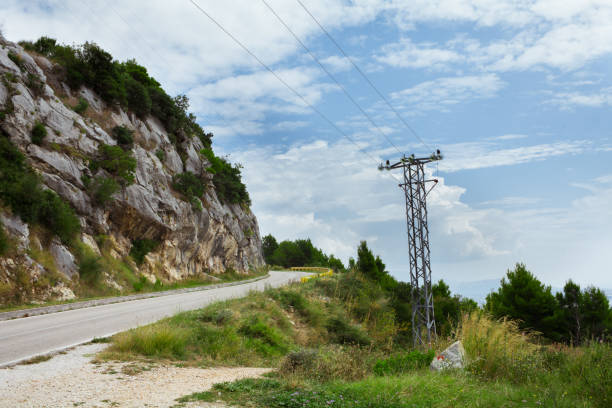 istock Mountain road near high voltage power line 1175483870