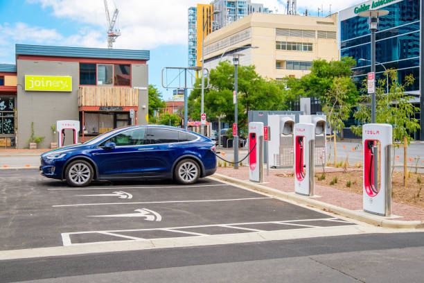 автомобиль tesla model x подключен к нагнетателю - street stall стоковые фото и изображения