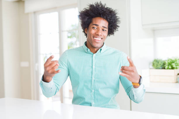 istock African American business man wearing elegant shirt shouting with crazy expression doing rock symbol with hands up. Music star. Heavy concept. 1175491625