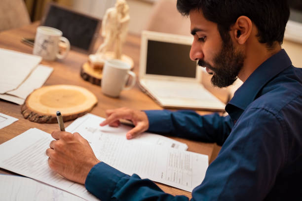 istock Man working at home, writing on exam paper 1175496104