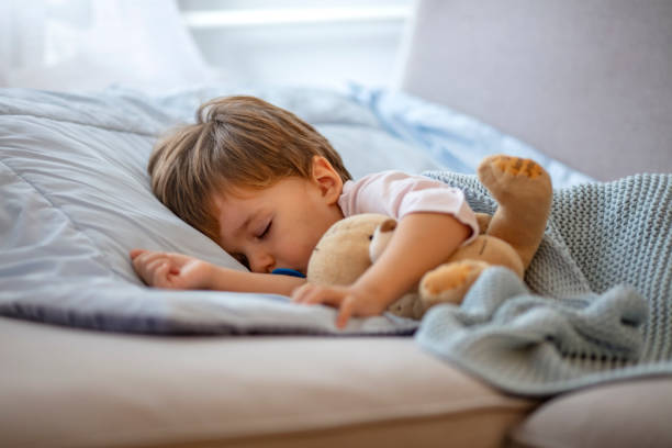istock Adorable toddler baby sleeping with plush toy in sofa 1175497294