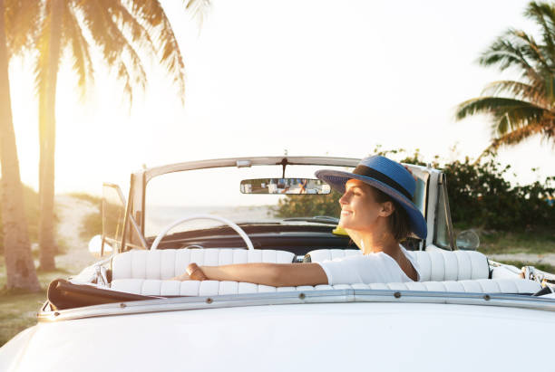 Happy young woman and retro convertible car