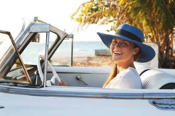 istock Happy young woman and retro convertible car 1175497821