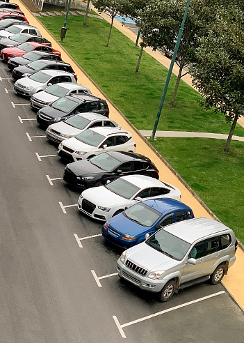 cars parked in a row in a street parking, top view