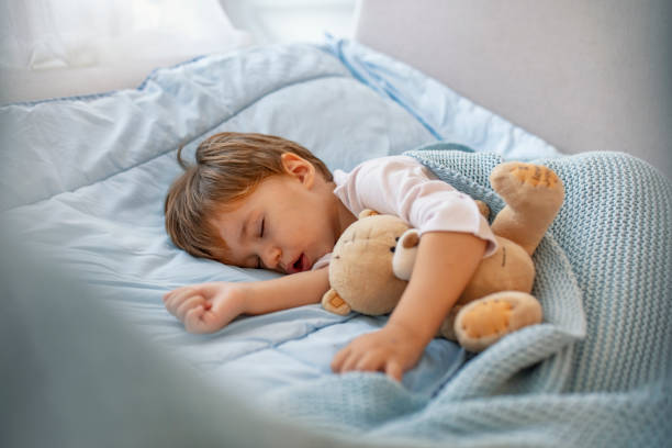 istock Adorable toddler baby sleeping with plush toy in sofa 1175498043