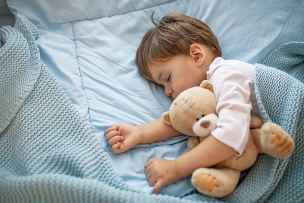 istock Baby toddler asleep with teddy bear 1175499099