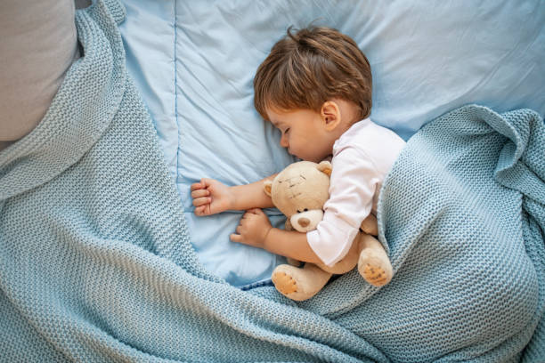 istock Adorable kid boy after sleeping in bed with toy 1175501584