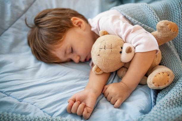 istock Baby toddler asleep with teddy bear 1175502602