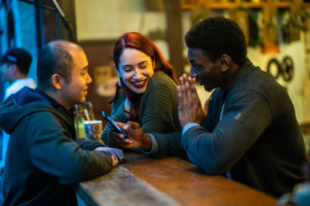 istock Multi.ethnic group of friends sharing memes on phone in cafeteria 1175503815