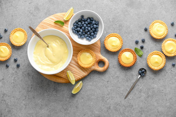 Tartlets with custard and summer berries Tartlets with custard and blueberry, top down view custard photos stock pictures, royalty-free photos & images