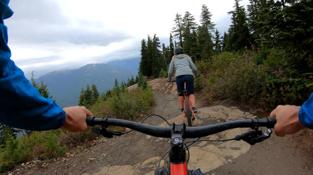 istock Female mountain biker rides on path through forest 1175506092