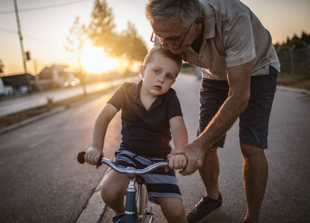 istock Grandfather teaching grandson biking 1175507917