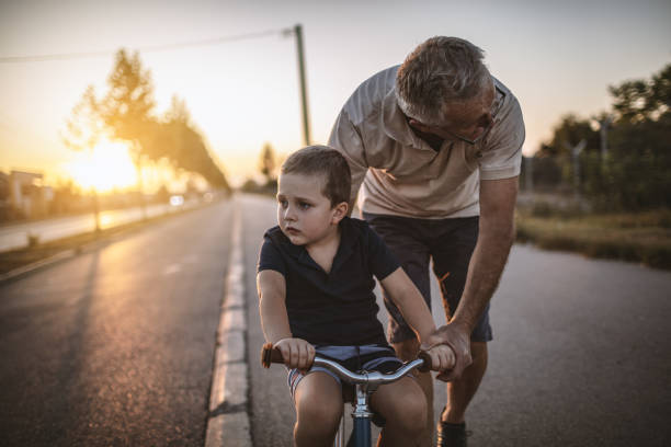 istock Grandfather teaching grandson biking 1175508042