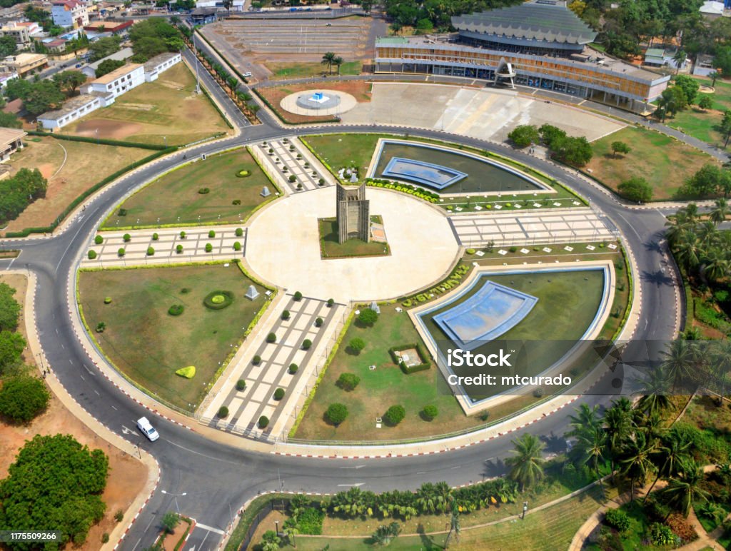 Lomé, Togo - the capital's main square, Independence Square, the center of the city and the country - Palais de Congrés on the top right and Independence monument in the center of the square Lomé, Togo: view over Independence Square (Place de l'Independance), a traffic circle that is the de facto center of the country - seen from above. Hedgerow: Independence, April 27th, 1960. Togo Stock Photo