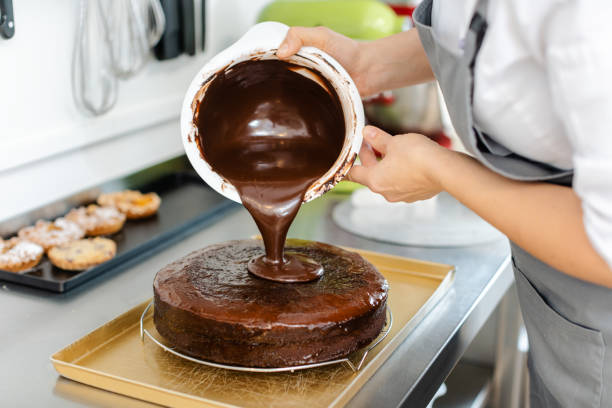 istock Patissier pouring liquid chocolate on a cake 1175510571