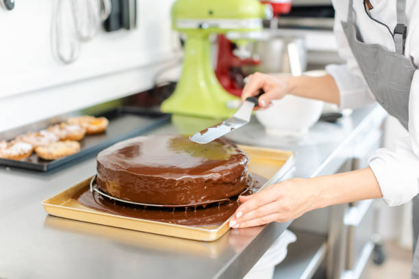 istock Patissier pouring liquid chocolate on a cake 1175510599